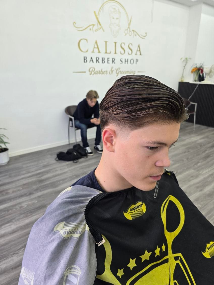 Fade-klippning i profil med bakåtkammat hår hos Salong Calissa i Malmö